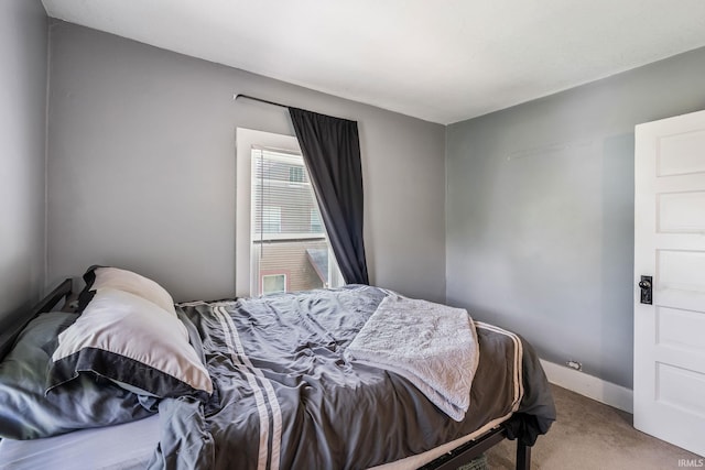 bedroom featuring carpet and baseboards