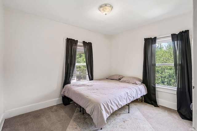 bedroom with light carpet and baseboards