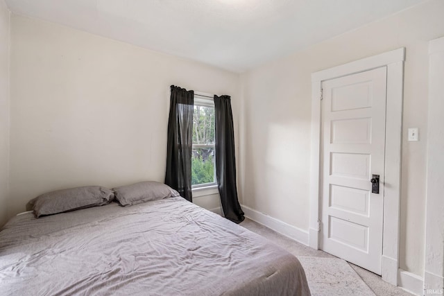 bedroom with baseboards and light carpet