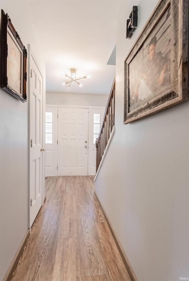 7860 Cedar Ridge Dr, Evansville, IN 47715 - foyer entrance featuring light wood finished floors, a chandelier, stairway, and baseboards