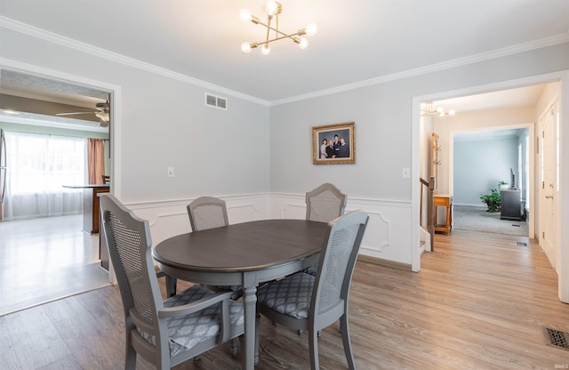 7860 Cedar Ridge Dr, Evansville, IN 47715 - dining space with a chandelier, light wood-type flooring, crown molding, and a wainscoted wall