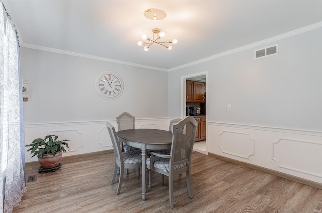7860 Cedar Ridge Dr, Evansville, IN 47715 - dining area with a chandelier, light wood-type flooring, crown molding, and a wainscoted wall