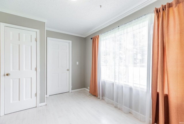 7860 Cedar Ridge Dr, Evansville, IN 47715 - unfurnished bedroom featuring light wood-style floors, crown molding, baseboards, and a textured ceiling