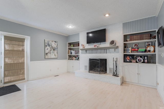 7860 Cedar Ridge Dr, Evansville, IN 47715 - unfurnished living room featuring a textured ceiling, wood finished floors, ornamental molding, a fireplace, and a wainscoted wall