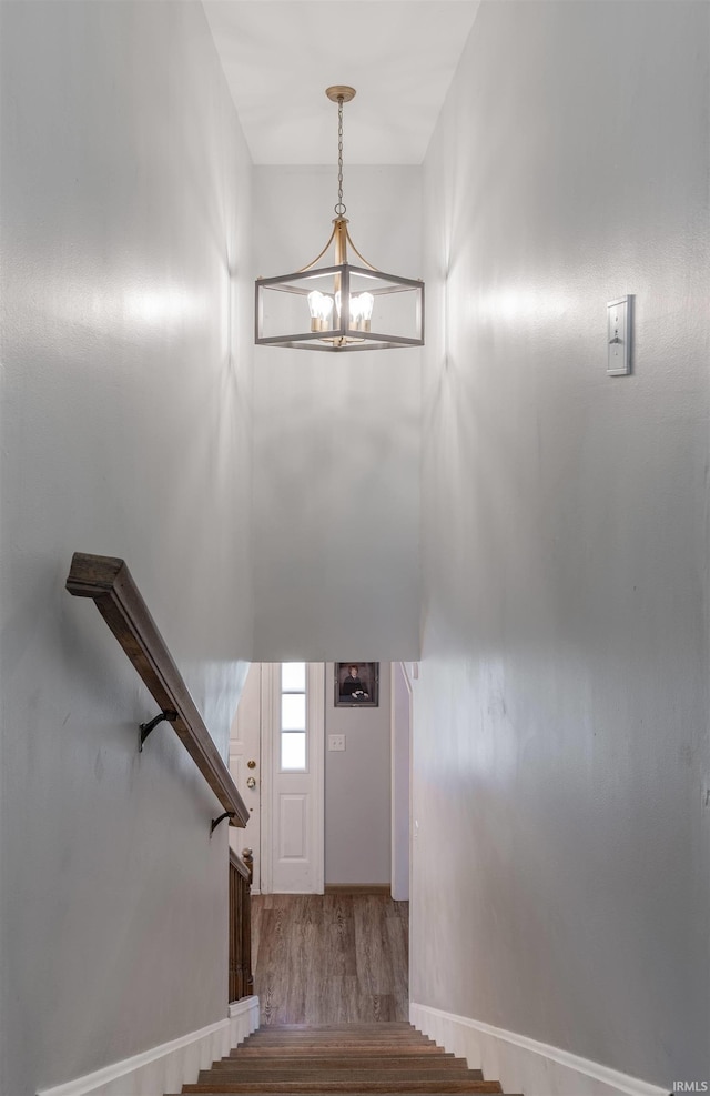 7860 Cedar Ridge Dr, Evansville, IN 47715 - stairway featuring wood finished floors, a chandelier, and baseboards
