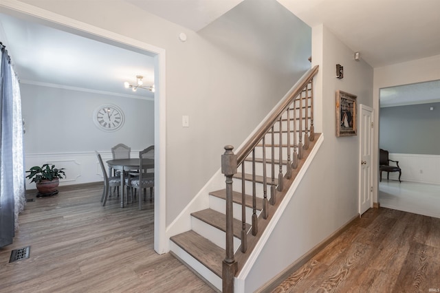 7860 Cedar Ridge Dr, Evansville, IN 47715 - stairway featuring wood finished floors, wainscoting, a chandelier, and ornamental molding