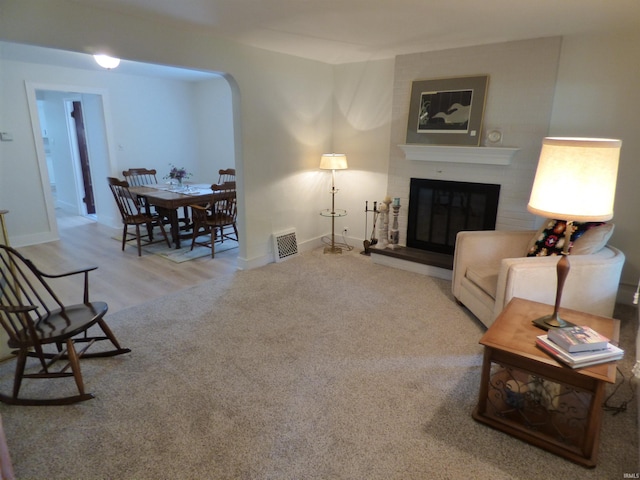 51044 Portage Rd, South Bend, IN 46628 - living room featuring arched walkways, a brick fireplace, baseboards, and wood finished floors