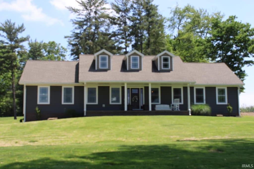 cape cod-style house with a front yard and a porch