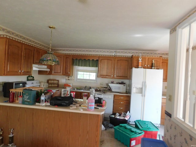 1702 Valley View Dr, Bedford, IN 47421 - kitchen featuring white appliances, under cabinet range hood, brown cabinets, light countertops, and a peninsula