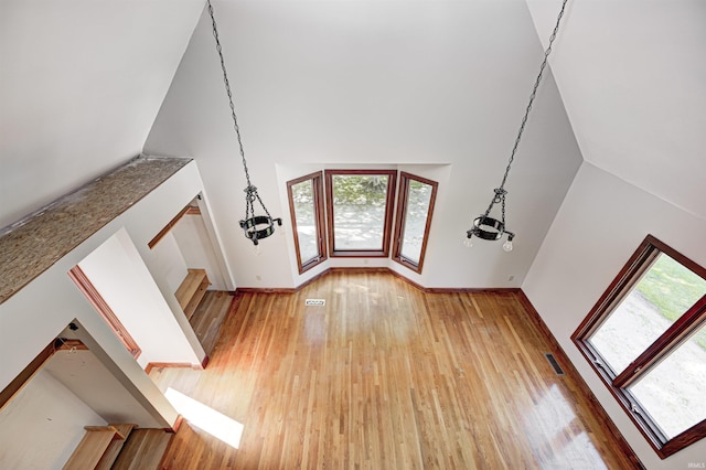 4302 Kessler Blvd N Drive, Indianapolis, IN 46220 - unfurnished living room featuring light wood-type flooring, high vaulted ceiling, and baseboards
