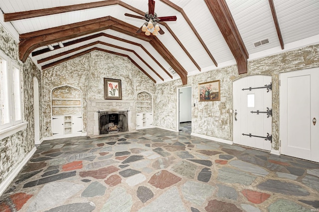 4302 Kessler Blvd N Drive, Indianapolis, IN 46220 - unfurnished living room featuring stone floors, ceiling fan, a fireplace, beamed ceiling, and high vaulted ceiling