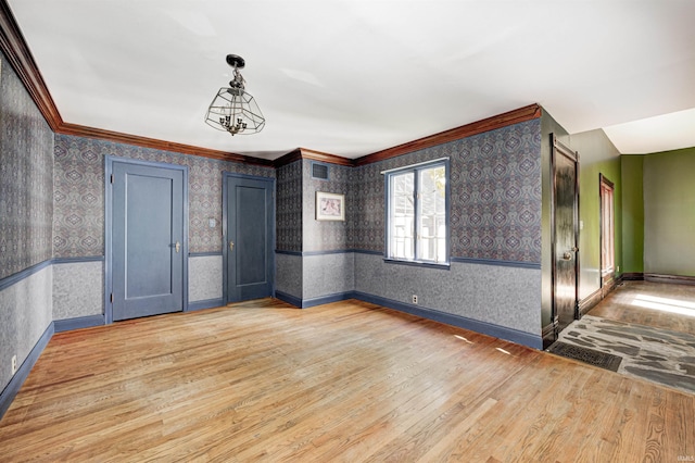 4302 Kessler Blvd N Drive, Indianapolis, IN 46220 - spare room with wallpapered walls, light wood-style floors, wainscoting, ornamental molding, and baseboards