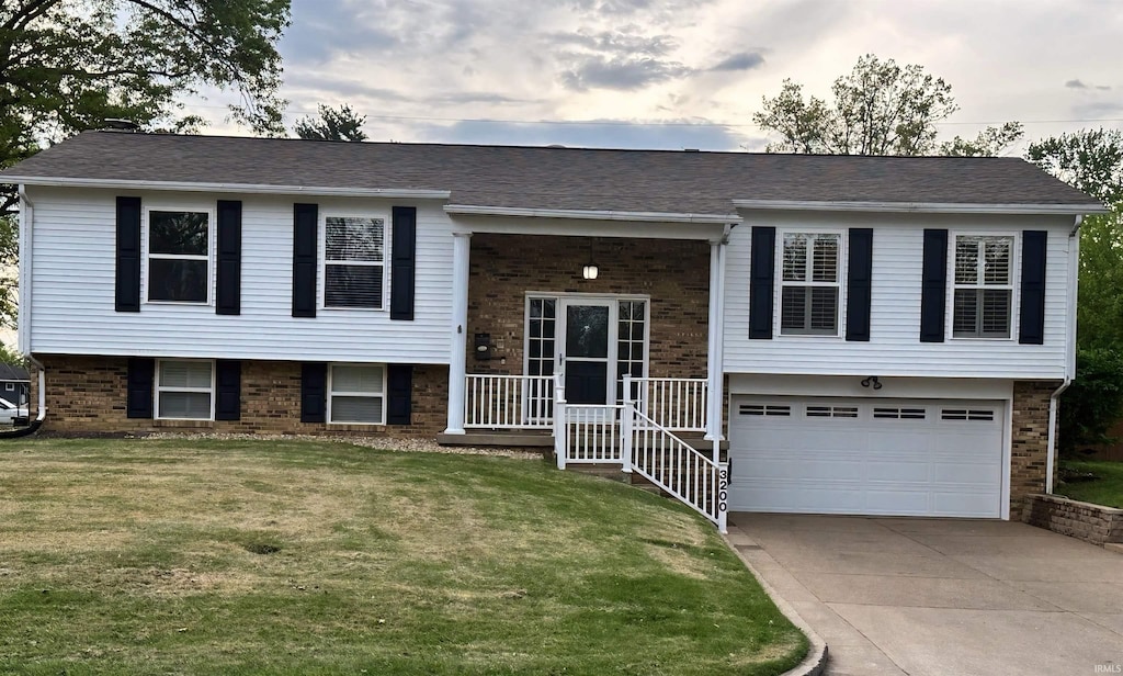 3200 Mockingbird Ln, Evansville, IN 47710 - raised ranch with brick siding, driveway, a garage, and a front lawn