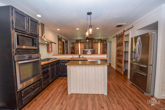 1809 E Royerton Rd, Muncie, IN 47303 - kitchen with stainless steel appliances, wall chimney range hood, a peninsula, dark wood-type flooring, and a sink