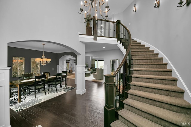19861 County Road 16, Bristol, IN 46507 - stairway with a chandelier, arched walkways, wood finished floors, a towering ceiling, and ornamental molding