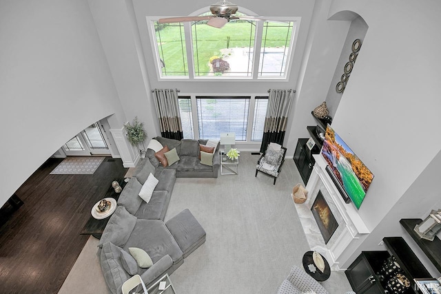 19861 County Road 16, Bristol, IN 46507 - living room with arched walkways, a high ceiling, ceiling fan, wood finished floors, and a fireplace with flush hearth