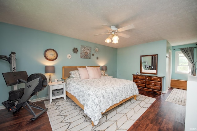 bedroom featuring wood finished floors, baseboards, a textured ceiling, and ceiling fan