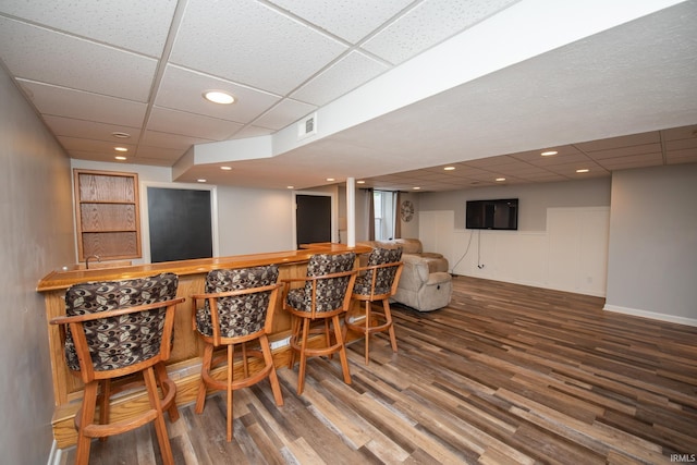 indoor dry bar with a drop ceiling, wood finished floors, and recessed lighting