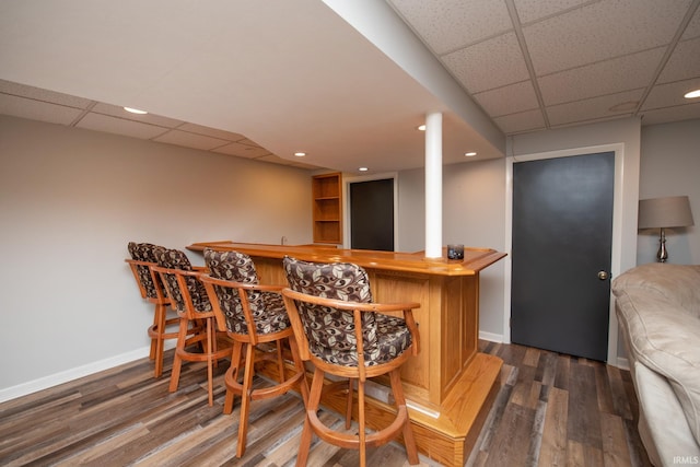 indoor dry bar with a paneled ceiling, wood finished floors, baseboards, and recessed lighting