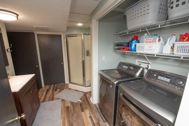 washroom with washer and clothes dryer and wood finished floors