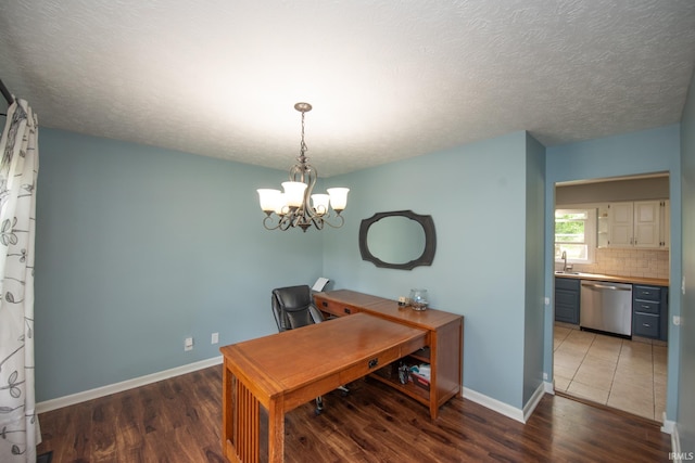 office space featuring wood finished floors, baseboards, a chandelier, a sink, and a textured ceiling