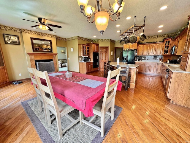 5936 County Road 427, Auburn, IN 46706 - dining room featuring a chandelier, light wood-type flooring, a fireplace, a textured ceiling, and recessed lighting