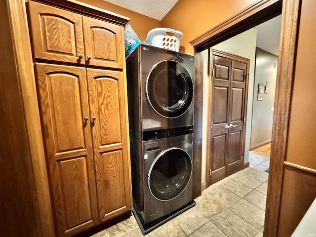 5936 County Road 427, Auburn, IN 46706 - laundry area with estacked washer and dryer, cabinet space, light tile patterned floors, and a textured ceiling