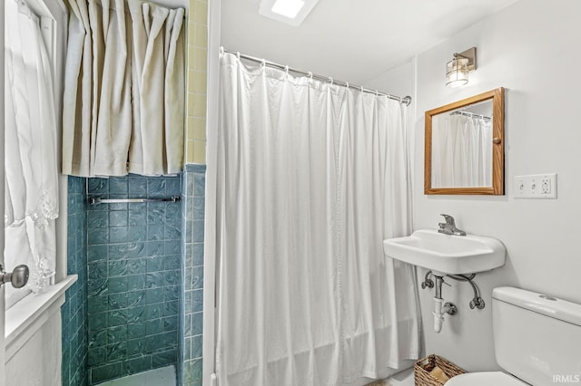 full bath featuring toilet, a shower with shower curtain, and a sink