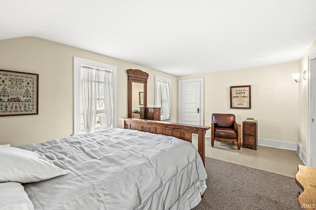 carpeted bedroom featuring baseboards and lofted ceiling