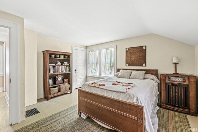 bedroom featuring vaulted ceiling and wood finished floors