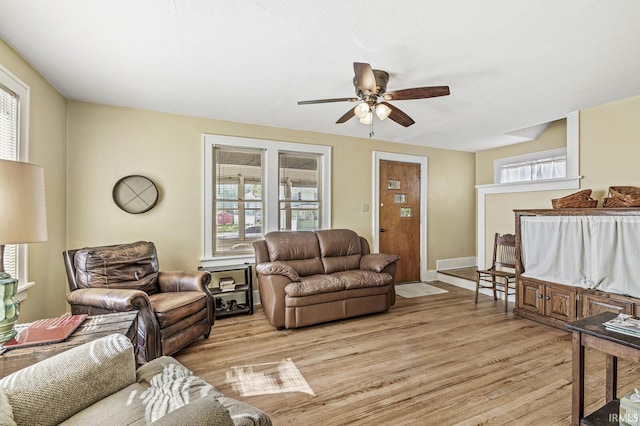 living area with ceiling fan, light wood-style flooring, and baseboards