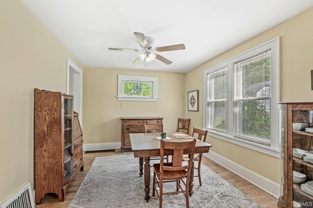 dining space featuring ceiling fan, light wood-type flooring, and baseboards