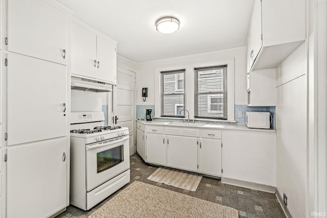 kitchen with white appliances, under cabinet range hood, a sink, white cabinets, and light countertops