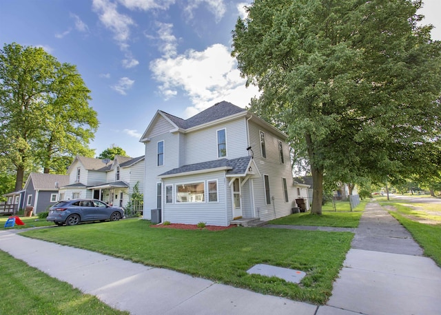 201 N Gonser Ave, Ashley, IN 46705 - traditional home with a front lawn, a shingled roof, and cooling unit