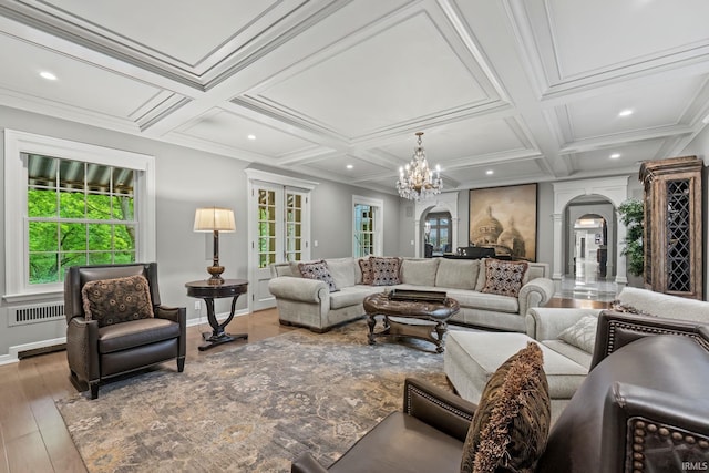 living area featuring arched walkways, coffered ceiling, baseboards, recessed lighting, and a chandelier