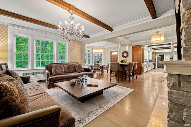 living room featuring beamed ceiling, a chandelier, light wood-style flooring, crown molding, and radiator