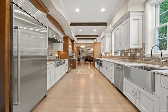 kitchen featuring stainless steel appliances, a sink, crown molding, backsplash, and recessed lighting