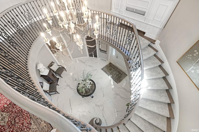 stairs featuring a chandelier and a high ceiling
