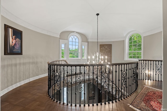 hallway with a chandelier, an upstairs landing, baseboards, and crown molding