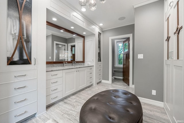 bathroom featuring ornamental molding, wood finished floors, baseboards, a chandelier, and vanity