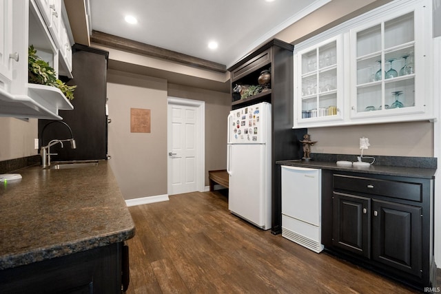 kitchen featuring white appliances, open shelves, dark countertops, dark wood-style floors, and a sink