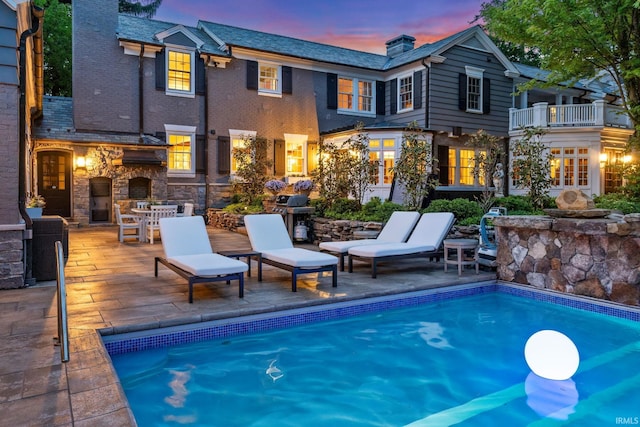 swimming pool with a patio and grilling area