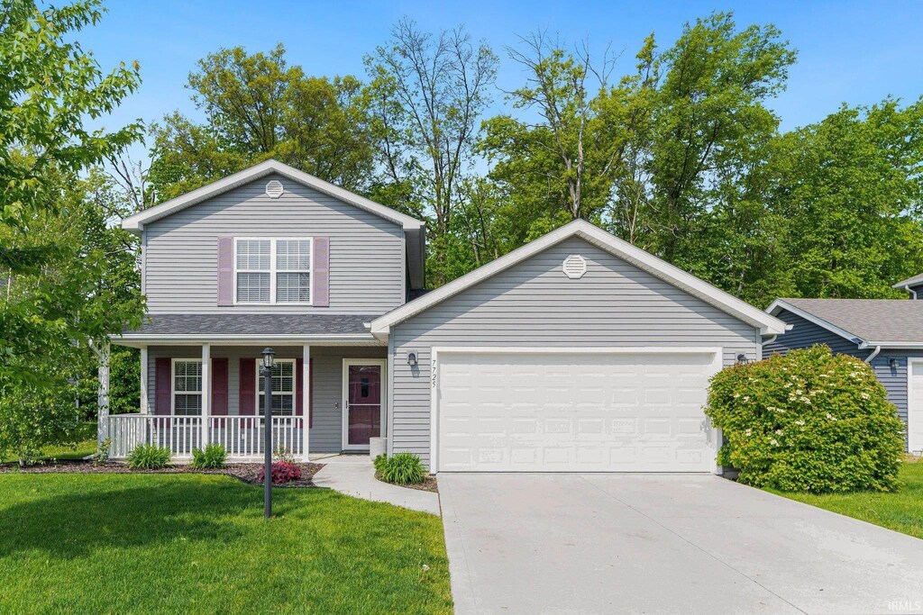7725 Payne Pkwy, Fort Wayne, IN 46818 - traditional-style house featuring a porch, a garage, concrete driveway, and a front lawn