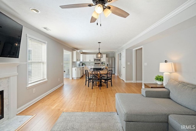 3154 Sand Walk Dr, Kokomo, IN 46902 - living area featuring ornamental molding, a fireplace, light wood-style floors, baseboards, and a ceiling fan