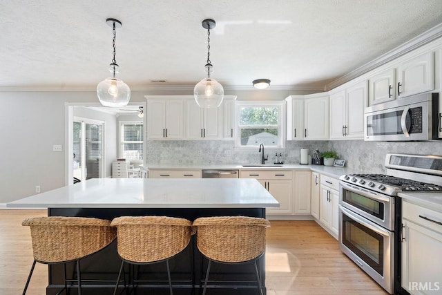 3154 Sand Walk Dr, Kokomo, IN 46902 - kitchen with stainless steel appliances, a sink, a kitchen breakfast bar, decorative backsplash, and white cabinetry