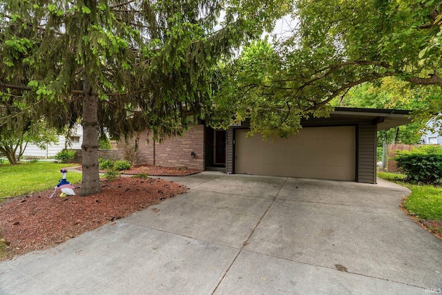 view of property hidden behind natural elements with driveway and an attached garage