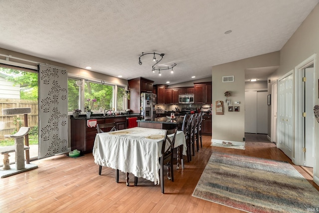 dining area with light wood-style flooring, baseboards, recessed lighting, and a textured ceiling