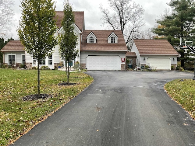 15560 Menominee Dr, Plymouth, IN 46563 - new england style home with stone siding, asphalt driveway, and a front yard