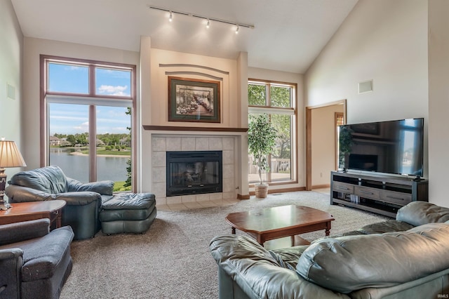 9725 Sea View Cv, Fort Wayne, IN 46835 - living room with carpet floors, track lighting, vaulted ceiling, a tiled fireplace, and a water view