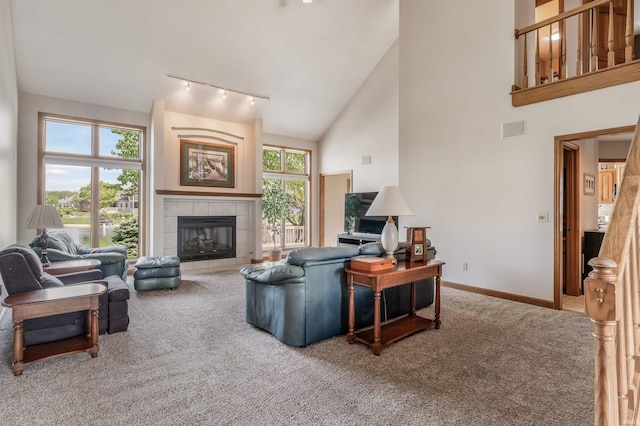 9725 Sea View Cv, Fort Wayne, IN 46835 - living room with carpet floors, rail lighting, baseboards, a tile fireplace, and high vaulted ceiling